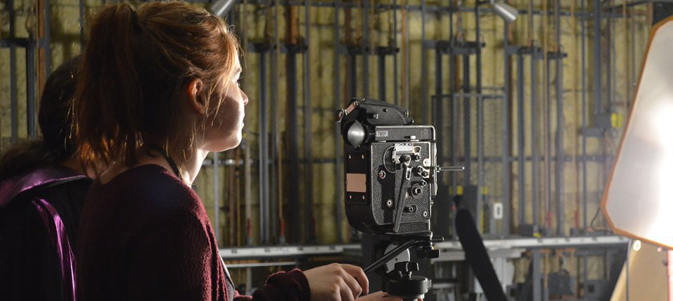 Photo of student shooting film with Bolex camera on soundstage