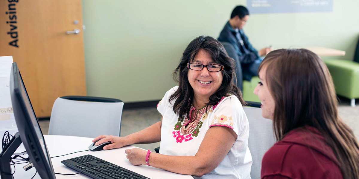Photo of Academic Adviser Nicky Trasviña working with a student in the Advising Resource Center