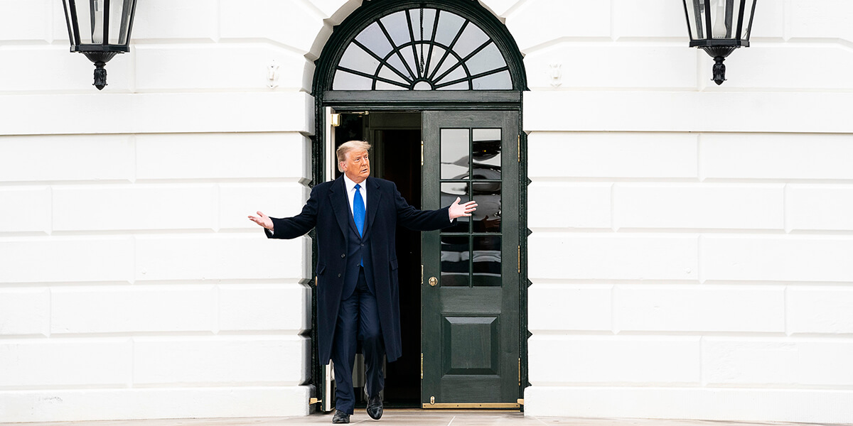 Donald Trump walking out of door and gesturing with his hands on South Lawn of White House