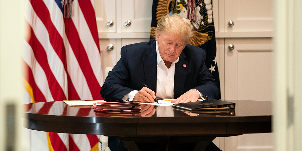 Photo of Donald Trump writing on piece of paper at desk in Presidential Suite of Walter Reed Military Medical Center