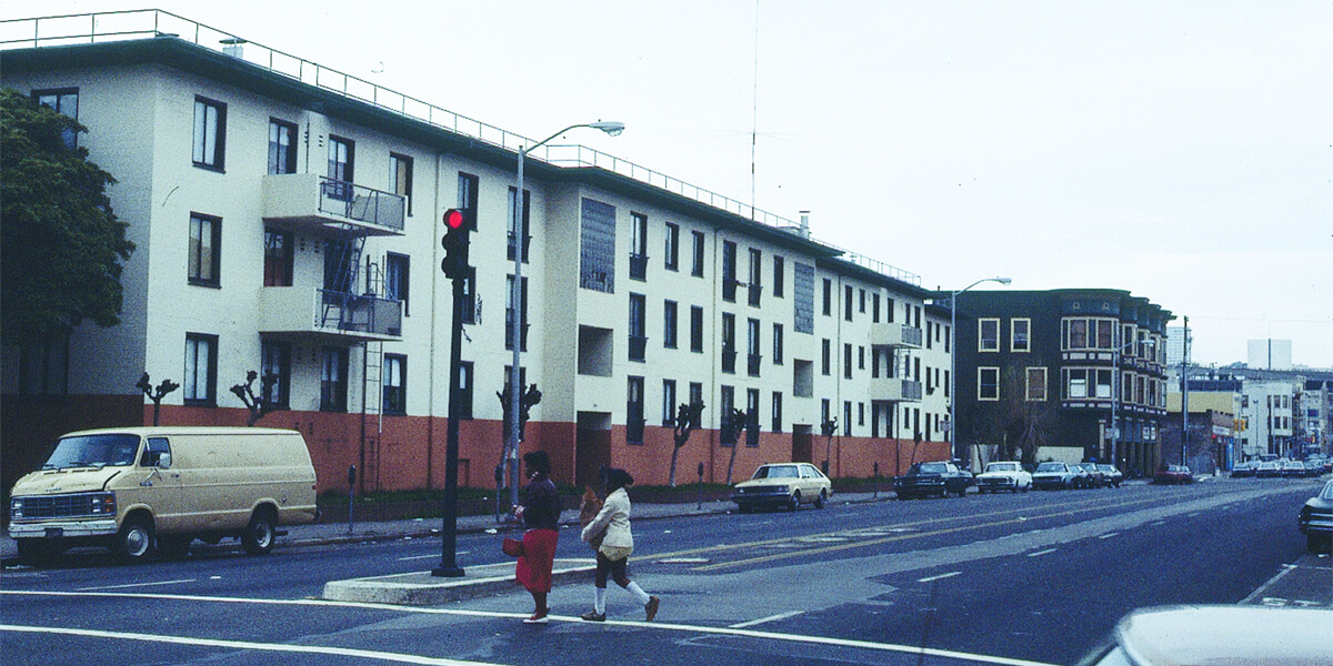 Photo of women crossing the street in front of San Francisco's Valencia Gardens housing project, circa 1983