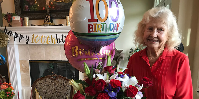 Lucille Wendling smiles with 100th birthday balloons