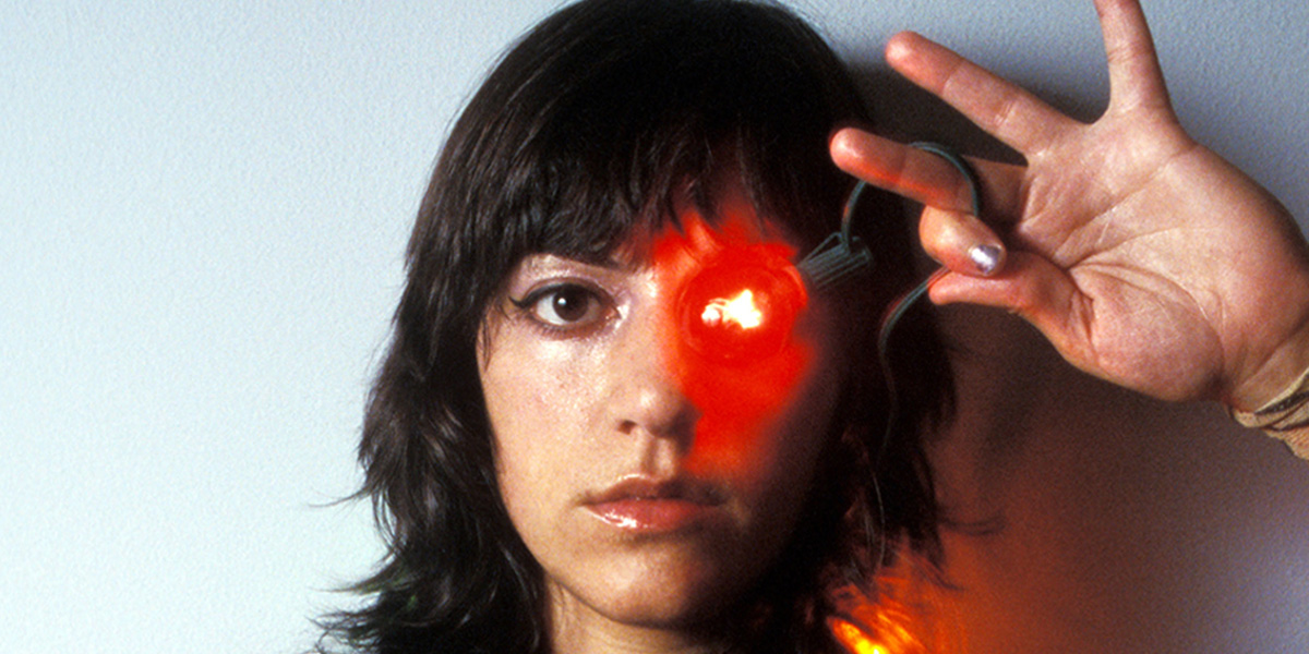 Photo of Ana Lily Amirpour holding a red light over her left eye