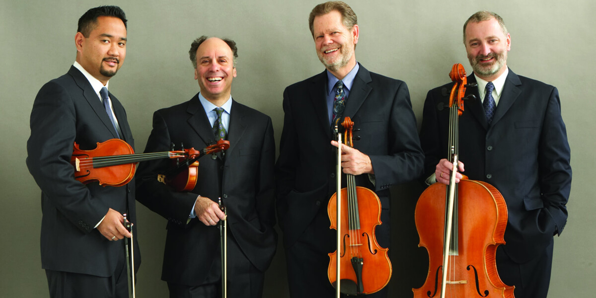 Photo of the Alexander String Quartet standing up and holding their instruments