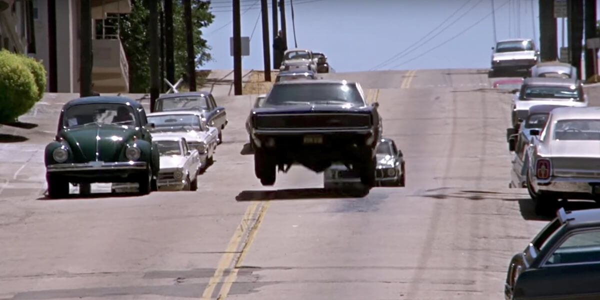 Still from scene in Bullitt of Ford Mustang getting air while on a car chase going downhill on a San Francisco street