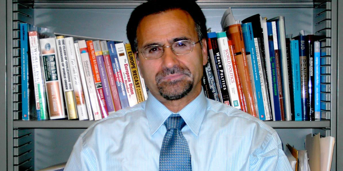 Photo of Mahmood Monshipouri in front of a bookshelf