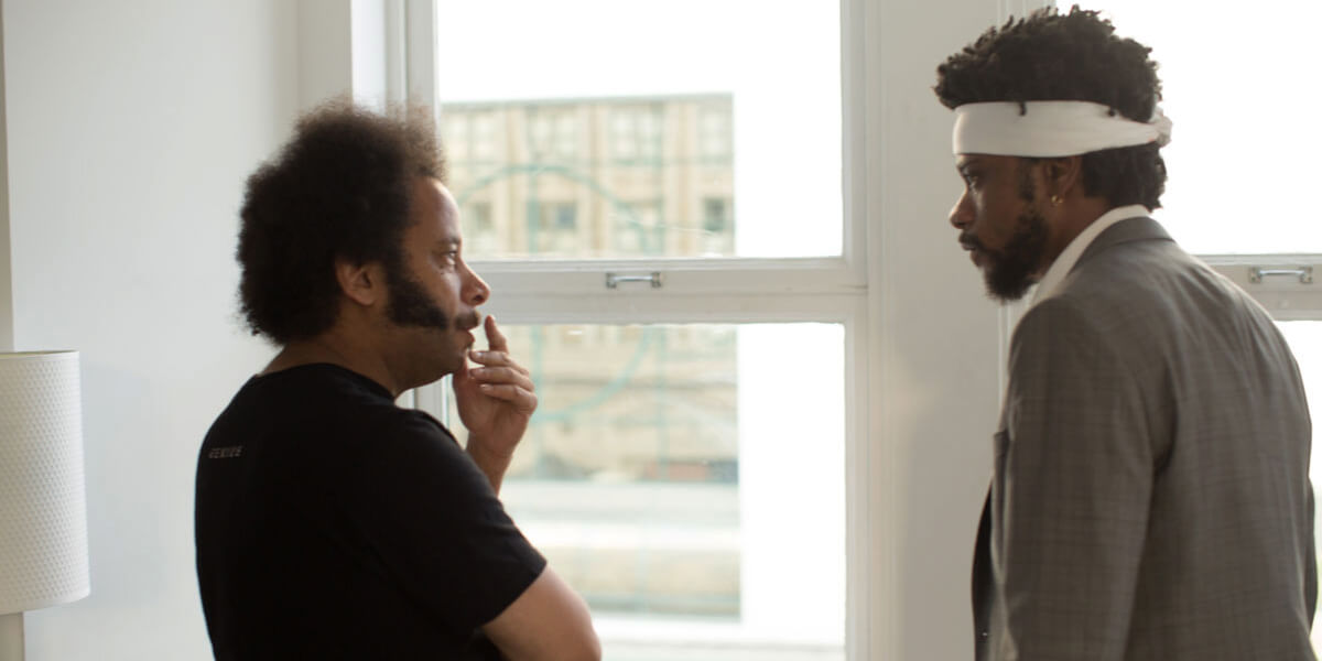 Photo of Boots Riley and Lakeith Stanfield talking to each other near a window