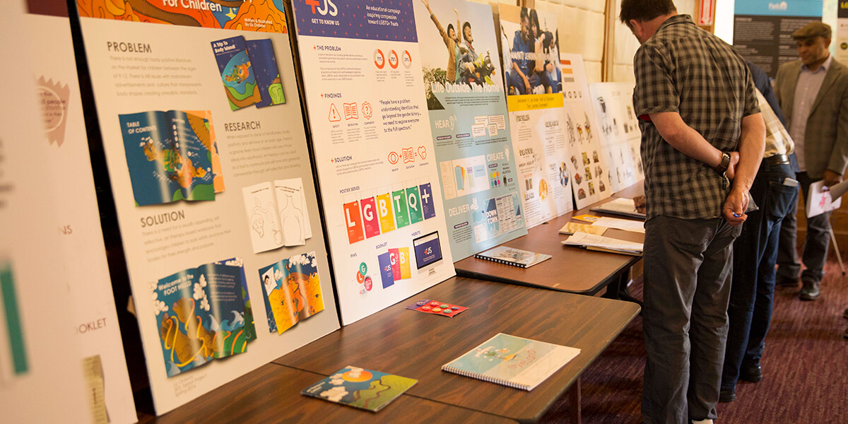 Research showcase attendees view pesentation material by students