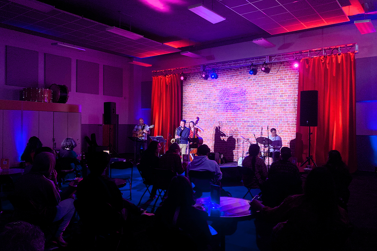 jazz performance in a brick band room with red and purple lights 
