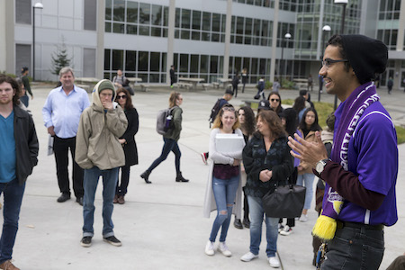 Student in purple talking to student on campus