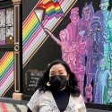 Houyee Chow stands in front of the mural she painted