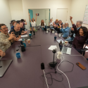 People sitting around a newsroom table