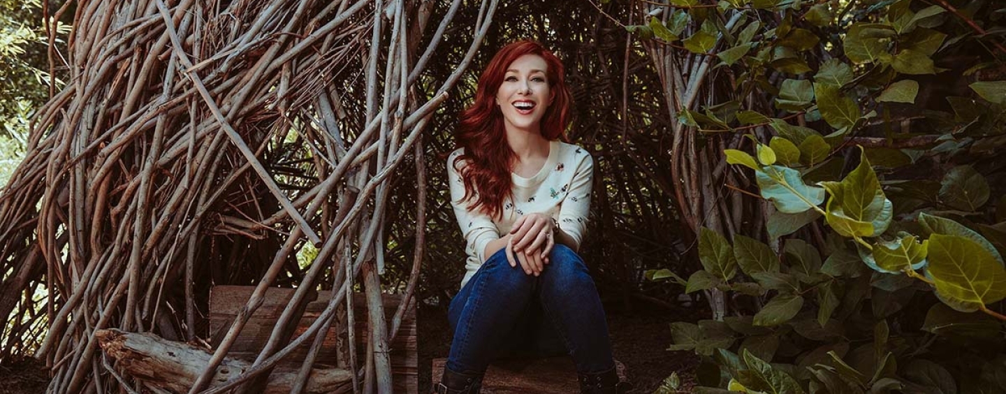 Red haired Ward sitting inside entwined tree branches looking like a hut
