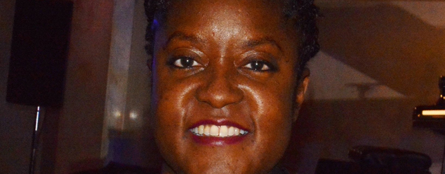 Tonya M. Foster smiling while standing indoors