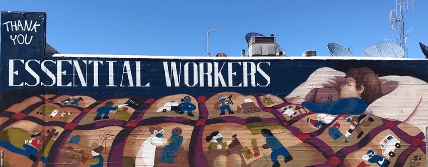 A mural depicting a boy sleeping under a quilt that depicts various essential workers accompanied by text Thank You Essential Workers