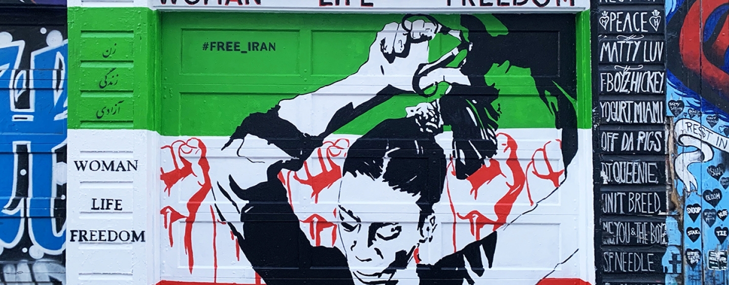 Farnaz Zabetian’s mural on a garage door on Clarion Alley in San Francisco depicts a woman cutting her hair in front of raised fists and the colors of the Iran flag