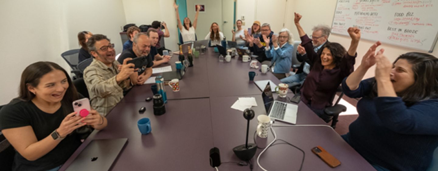 People sitting around a newsroom table