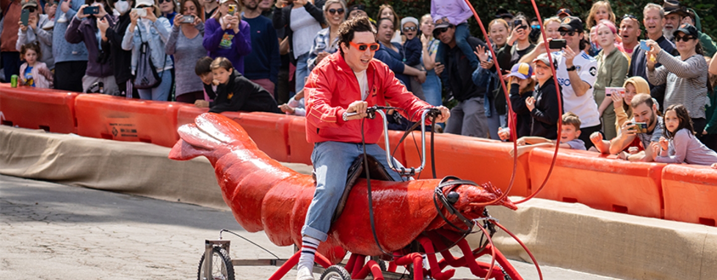 A handmade car shaped like a prawn races down a road inside John McLaren Park in San Francisco