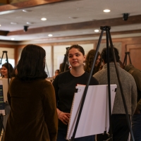A student talking to an attendee of their work