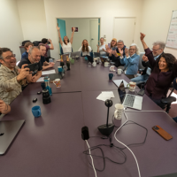 People sitting around a newsroom table