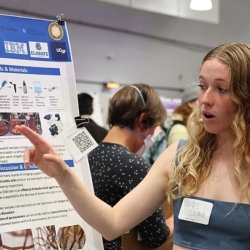 Student pointing at research during showcase event