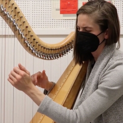Student playing the harp