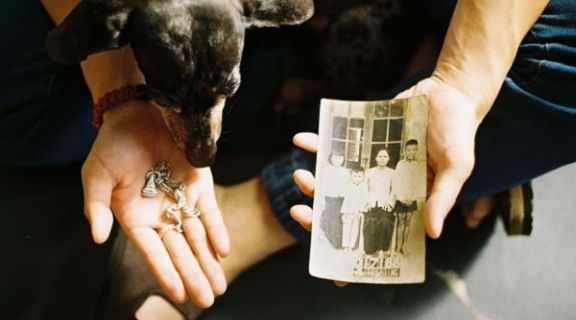 Person sitting with hands out holding a photo and a charm