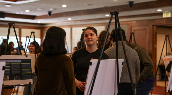 A student talking to an attendee of their work