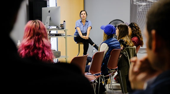 An alumna talks to students in a classroom