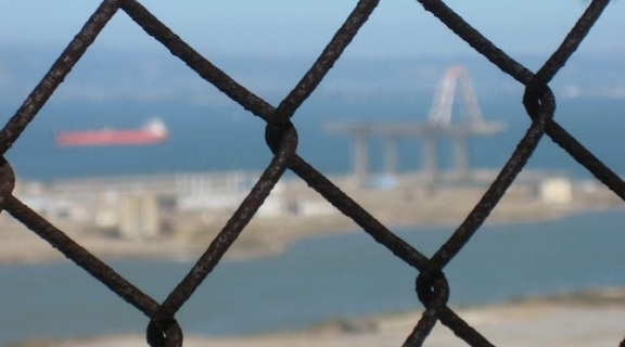 View of SF Bay and Hunter's Point through a chain fence