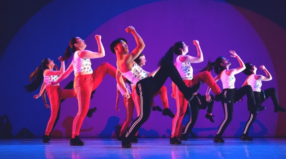 Dancers in tank tops and black and red striped pants